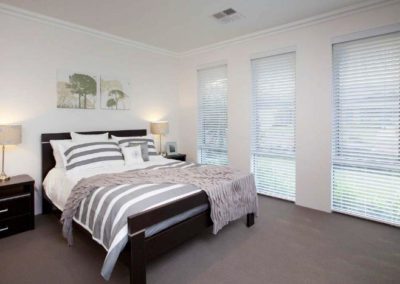 bedroom with three windows and venetian blinds