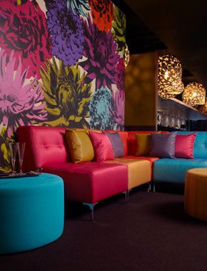 bright floral wallpaper with colourful couch interior