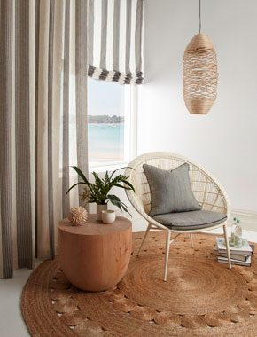 living room area with rattan rug and sheer striped curtains
